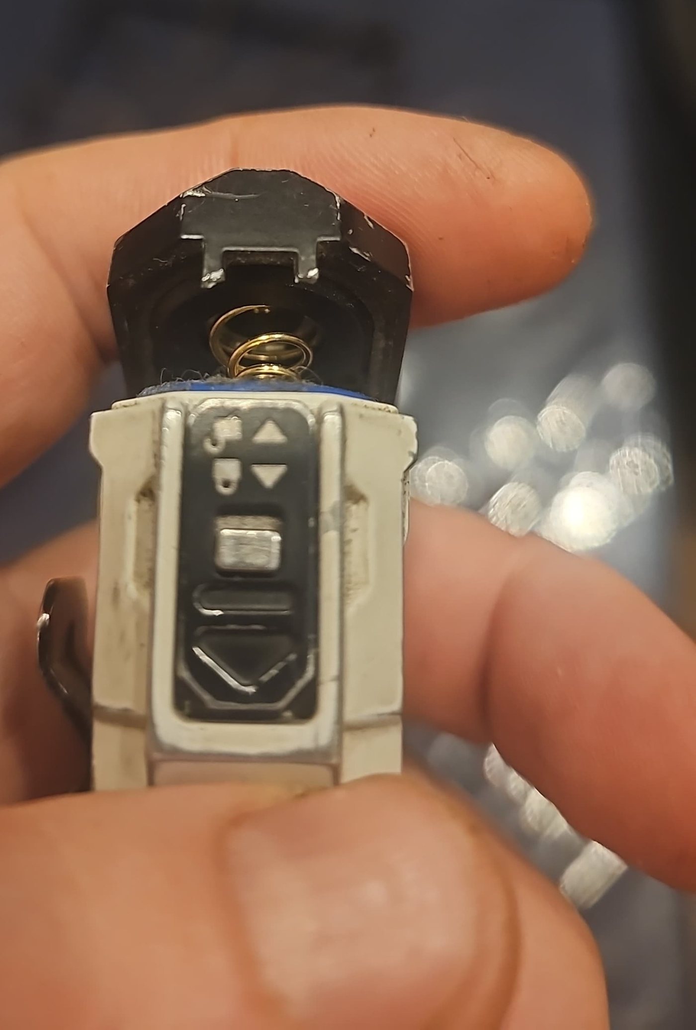 The Wuben X4's hinged battery door flipped open, showing the spring, above the slide switch